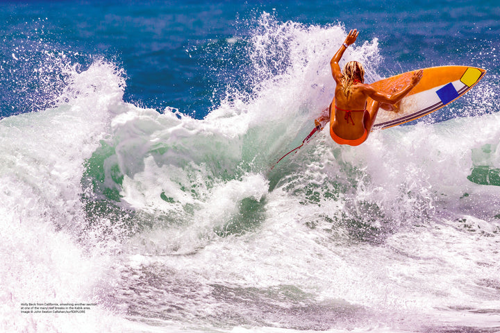 A surfer in an orange swimsuit rides a yellow board on vibrant blue waves. Discover uncharted surf spots with surfEXPLORE from Schiffer Publishing, Ltd.—the ultimate guide for adventurous surfers seeking new destinations.