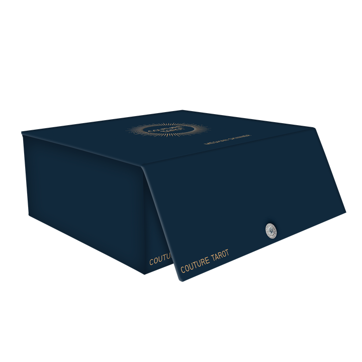 A dark blue rectangular Couture Tarot box by Schiffer Publishing, Ltd. with gold text on the flap, a small circular emblem, and a sunburst design on top is shown slightly open against a white background.