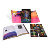 The Starman Tarot Remastered by Schiffer Publishing, Ltd. is shown with a colorful box, an open illustrated guidebook, and several tarot cards on a white surface—all featuring vivid psychedelic artwork by Davide De Angelis.