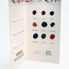 The Watercolor the Easy Way Paint Palette Portfolio Flowers by Schiffer Publishing, Ltd. features a swatch card with twelve labeled paint dots—magenta, red, purple, yellow, blue, green, orange, and gray—on textured paper with floral illustrations.