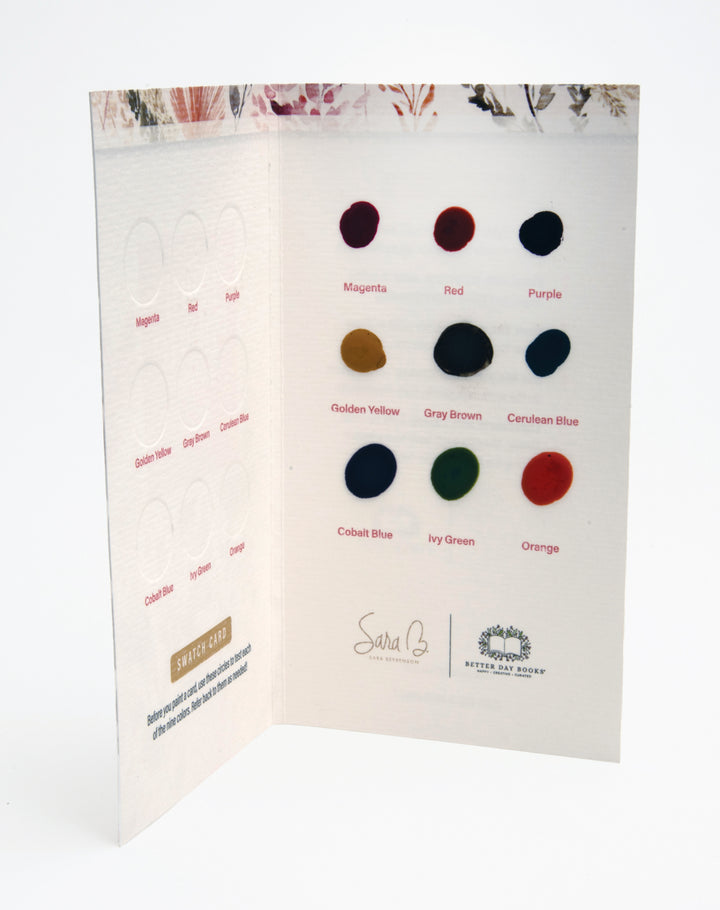 The Watercolor the Easy Way Paint Palette Portfolio Flowers by Schiffer Publishing, Ltd. features a swatch card with twelve labeled paint dots—magenta, red, purple, yellow, blue, green, orange, and gray—on textured paper with floral illustrations.