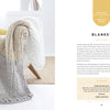 A cozy beige and gray chunky knit blanket is draped on a modern chair with yellow and white pillows. Beside it is "Get Started in Finger Knitting" by Schiffer Publishing, Ltd., showing a pattern page and blanket-making supplies.