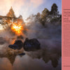 A golden sunrise shimmers over a misty river with rocks and trees. On the right, a text box reads, "The Complete Guide to America's National Parks," by Schiffer Publishing, Ltd., introducing this comprehensive travel guide.
