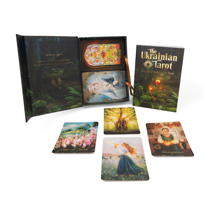 The Ukrainian Tarot by Schiffer Publishing, Ltd. shown with open box, illustrated guidebook, and six colorful cards depicting scenes from Slavic spiritual heritage, all arranged on a white background.