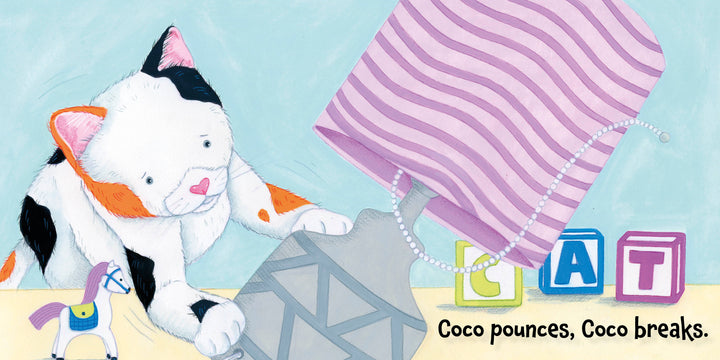 A calico cat named Coco knocks over a lamp near colorful blocks and a toy horse in Schiffer Publishing, Ltd.'s "Calm Down, Coco"—discover self-regulation strategies in this playful story.