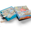 The Tiniest Giant 4-in-1 Puzzle Set by Schiffer Publishing, Ltd. features colorful animal artwork and illustrated pieces. The open box displays pieces inside and two scattered outside, inviting children to enjoy playful puzzling fun.