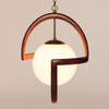 The Modeline of California by Schiffer Publishing, Ltd. is a pendant light with a glowing white globe in a curved wooden frame and brass accents, suspended from a gold chain—perfect for midcentury modern interiors.