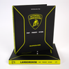 A black and yellow book titled "Automobili Lamborghini" by Schiffer Publishing, Ltd. stands upright on another copy, featuring a sleek cover with the iconic logo—a perfect gift for fans of luxury sports cars and Lamborghini legends.