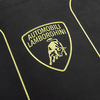Close-up of the Lamborghini logo with a gold bull and “Automobili Lamborghini” embroidered on black fabric, showcasing the elegance celebrated in every copy of Automobili Lamborghini Special Edition by Schiffer Publishing, Ltd.