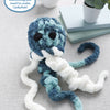 A plush blue and white jellyfish with big black eyes sits by books and tea. The label: Super Simple Finger Knitting Kit Jiggle the Jellyfish by Schiffer Publishing, Ltd.—includes everything needed to make your own cute jellyfish!.