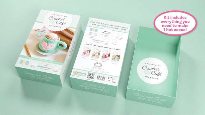 Three mint-green Crochet Cafe Amigurumi Kit Hot Cocoa boxes from Schiffer Publishing, Ltd. are shown: front, back, and open. The front features a crochet mug with heart; the back lists kit contents. Pink label: all supplies included!.