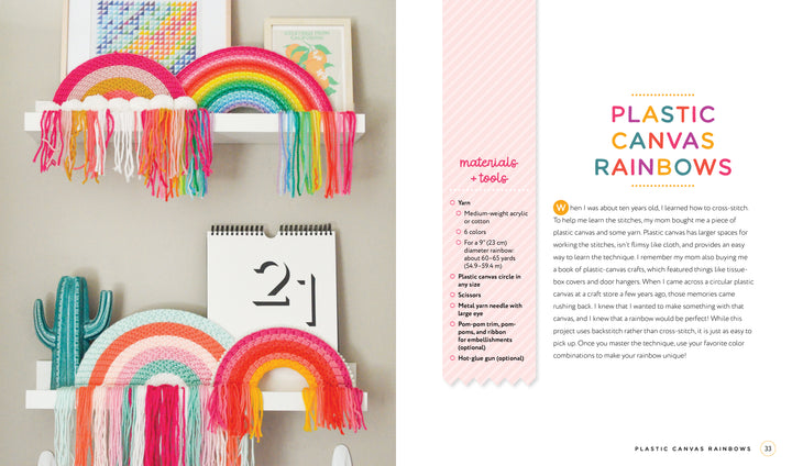 Two white shelves showcase colorful rainbow wall hangings inspired by Handmade Happiness Yarn Crafts from Schiffer Publishing, Ltd. A small cactus, calendar, and pastel artwork complete the display. Yarn crafts instructions are shown to the right.
