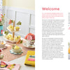 A table with cupcakes and flowers is accented by HeartFELT Crafts to Make and Give from Schiffer Publishing, Ltd., adding a charming touch of handmade decor.