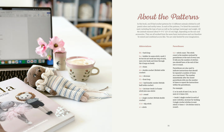 A laptop, a coffee mug, pink flowers in a vase, an amigurumi animal, and the "Sweet and Simple Amigurumi Friends" crochet book by Schiffer Publishing, Ltd. rest on a white table. An "About the Patterns" page is open on the right.