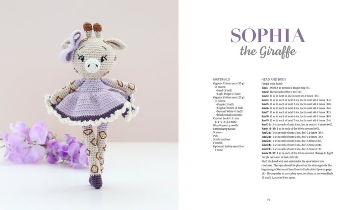 A crocheted giraffe doll in a purple dress stands on a white surface, with purple flowers to the left and Schiffer Publishing’s "Sweet and Simple Amigurumi Friends" amigurumi pattern for Sophia the Giraffe to the right.