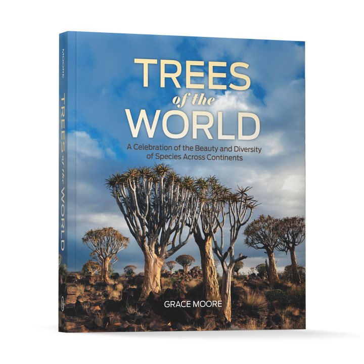 The cover of Trees of the World by Schiffer Publishing, Ltd. shows tall, distinct trees in a dry landscape under a partly cloudy sky. The book’s subtitle highlights its celebration of tree species’ beauty and diversity worldwide.