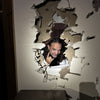 A man with long hair smiles and flashes a rock-and-roll hand sign through a hole in beige drywall, as if he’s just uncovered one of Savannah's mysteries from "Savannah's Afterlife III" by Schiffer Publishing, Ltd.