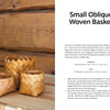Three small Bark Craft baskets by Schiffer Publishing, Ltd. are displayed on a wooden surface with a rustic backdrop. Text explains birch bark weaving techniques for creating an oblique woven basket.