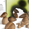 A set of wooden bird sculptures created with techniques from "Stamping on Wood" by Schiffer Publishing, Ltd. is displayed before a green and black abstract artwork, alongside text about wood coloring, heartwood, and sapwood on the left.