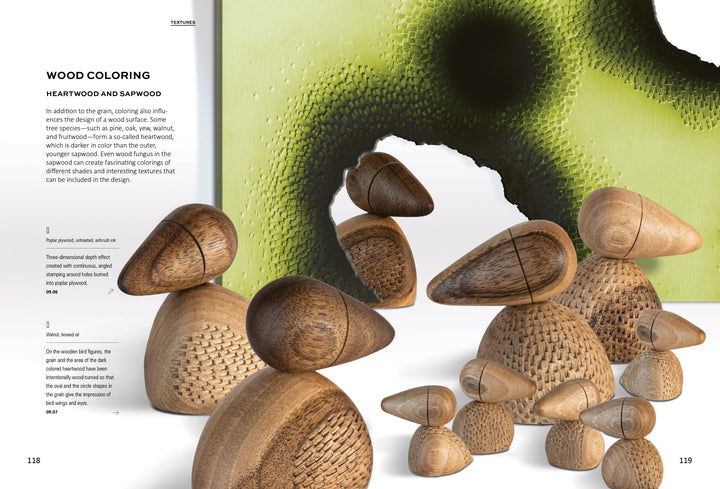A set of wooden bird sculptures created with techniques from "Stamping on Wood" by Schiffer Publishing, Ltd. is displayed before a green and black abstract artwork, alongside text about wood coloring, heartwood, and sapwood on the left.