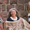 Three smiling women stand outside by a stone wall. The woman in the center holds Eco-Print, from Schiffer Publishing, Ltd., while one wears glasses and a sweater and the other is dressed in a striped shirt.