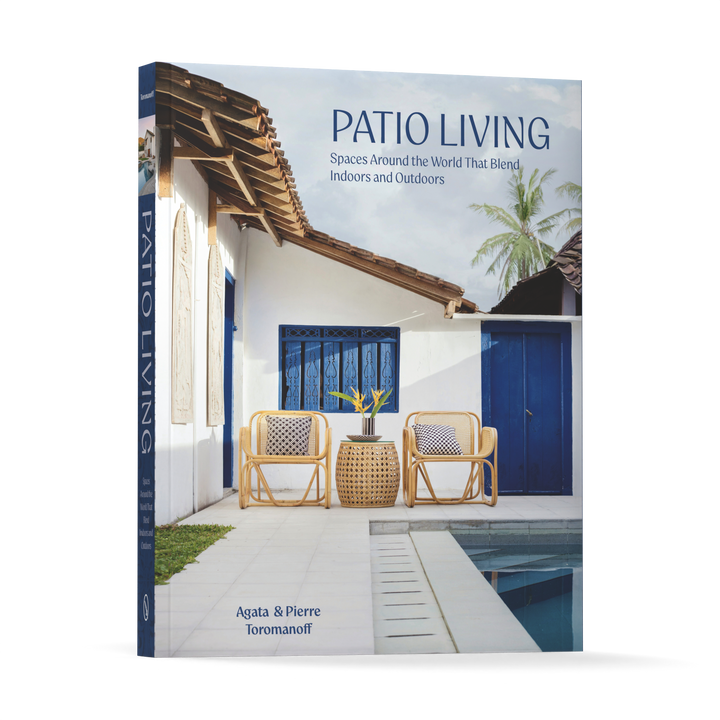 Patio Living by Schiffer Publishing, Ltd. features a cover with modern patio houses, rattan chairs, a small table, blue doors, white walls, and a palm tree in the background.