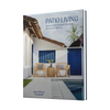 Patio Living by Schiffer Publishing, Ltd. features a cover photo of a stylish patio with two wicker chairs, a small table, and potted plants—highlighting modern indoor-outdoor living against a white house with blue doors and tropical greenery.