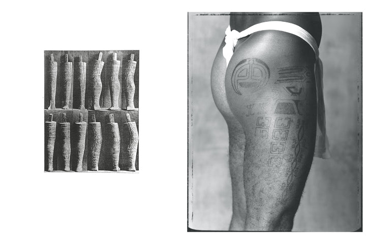 Black and white photo from "Tahiti Tattoos" by Schiffer Publishing, Ltd. shows ancient wooden tribal figurines beside a person's upper thigh adorned with bold Tahitian tattoos—a striking tribute to tattoo history.
