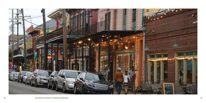 A row of parked cars lines a lively French Quarter street with colorful buildings, string lights, and outdoor seating—capturing the vibrant spirit found in "New Orleans" by Schiffer Publishing, Ltd.