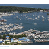 Aerial view of sailboats and yachts docked at piers, with lush trees and waterfront buildings near Shores & Islands Ohio, a top Midwest vacation spot. Featured by Schiffer Publishing, Ltd., on a sunny day.
