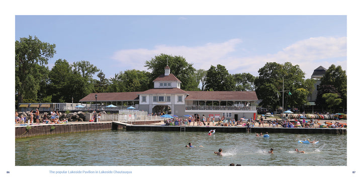 People enjoy swimming and relaxing by the Lakeside Pavilion, a light-colored building with a tower amid trees on a sunny day—capturing Midwest getaways featured in "Shores & Islands Ohio" by Schiffer Publishing, Ltd.