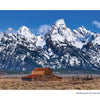 In Grand Teton National Park, a wooden barn and fence sit in an open field before snow-capped peaks under a blue sky. From Schiffer Publishing, Ltd.