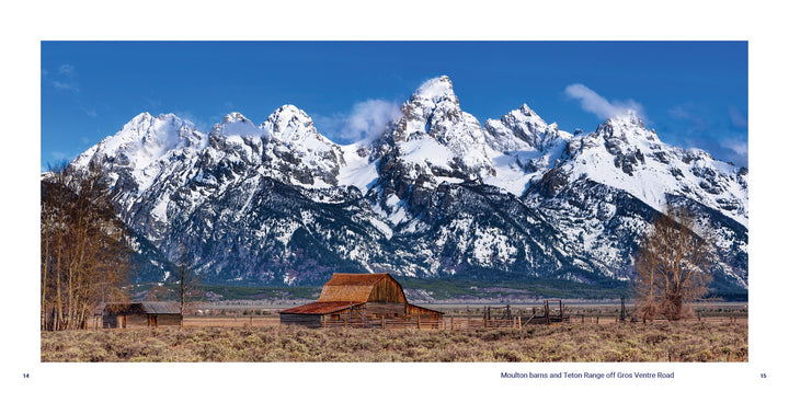 In Grand Teton National Park, a wooden barn and fence sit in an open field before snow-capped peaks under a blue sky. From Schiffer Publishing, Ltd.