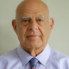 An older bald man in a light purple shirt and colorful paisley tie faces the camera against a plain light background, capturing the calm vibes of "Outer Banks" by Schiffer Publishing, Ltd.