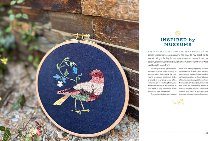 Wild Embroidery by Schiffer Publishing, Ltd. features a vibrant bird and blue-white flower stitched on dark fabric, displayed upright on pebbles with text about museums, art inspiration, and nature embroidery designs to the right.