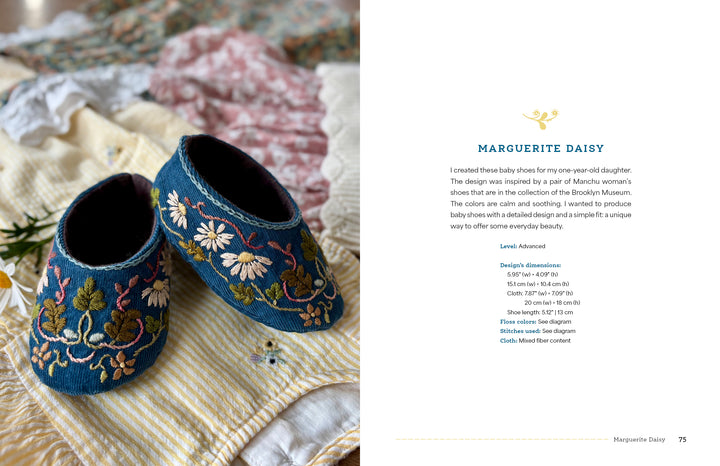 A pair of small, dark blue baby shoes from "Wild Embroidery" by Schiffer Publishing, Ltd. rest on a light yellow and white striped cloth. Text about the shoe design appears on the right side of the image.