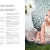 A baby sits outside on a gray blanket, wearing a cream romper inspired by KlompeLOMPE patterns from "Baby Knits from Norway" by Schiffer Publishing, Ltd., with lace and ruffles, gazing upward while white flowers blur in the background.