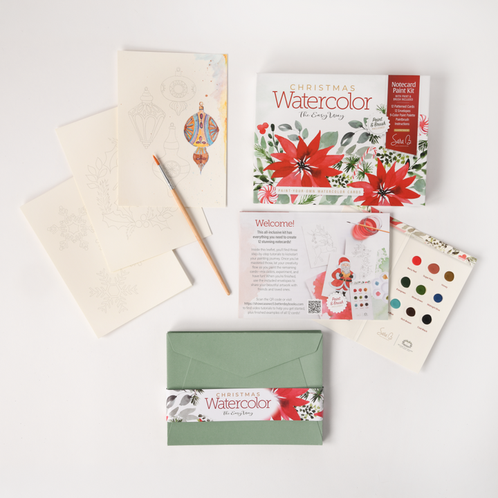 Watercolor the Easy Way Paint-Your-Own Watercolor Cards Christmas by Schiffer Publishing, Ltd. includes a palette, pencil, instructions, green envelope, card with poinsettias, and themed watercolor paper—everything for festive holiday cards.