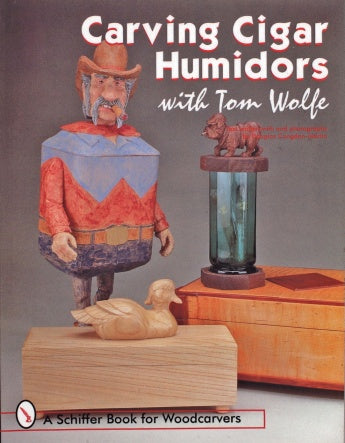 Book cover for "Carving Cigar Humidors with Tom Wolfe" by Schiffer Publishing, Ltd., featuring woodcarved designs—a cowboy, duck, and bear on a pillar. Ideal for cigar smokers and woodcarving enthusiasts.