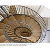 A top-down view of a spiral staircase with wooden steps and a bronze railing, evoking elegant metal sculpture—echoing the artistry found in Ironwork Today 3 by Schiffer Publishing, Ltd. Modern design and shadows accentuate the spiral form.