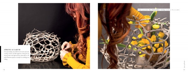 A red-haired woman in a yellow sweater arranges yellow flowers and greenery in a large, round, white basket atop a black surface, inspired by "Perishable Poetics" from Schiffer Publishing, Ltd.—a blend of nature and art.