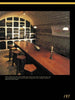 Schiffer Publishing, Ltd.'s Wine Cellar Design blends historic charm and inviting ambiance with an arched stone ceiling, bottle-lined shelves, a wooden table, and warm pendant lights for a rustic yet luxurious look.