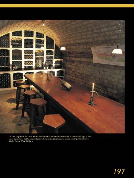 Schiffer Publishing, Ltd.'s Wine Cellar Design blends historic charm and inviting ambiance with an arched stone ceiling, bottle-lined shelves, a wooden table, and warm pendant lights for a rustic yet luxurious look.