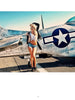 A woman poses in front of a vintage silver airplane, channeling the look from Alvarado's Classic Modern Pin-ups by Schiffer Publishing, Ltd.—a modern take on pin-up style inspired by classic photography.