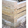 Wood in Traditional Architecture by Schiffer Publishing, Ltd. highlights expert carpentry—timber logs precisely stacked with interlocking notches on a stone foundation, exemplifying traditional architectural methods.