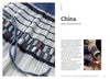 A close-up of a pleated skirt with black, white, and blue stripes appears on the left page; on the right, two people handcraft pleats outdoors in *Threads Around the World* by Schiffer Publishing, Ltd., highlighting heritage textile crafts.