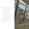 Australia Modern by Schiffer Publishing, Ltd. showcases a modern bedroom with glass walls framing a tree-lined view, minimalist decor, and natural light. A wood-accented hallway offers coastal vistas, reflecting the elegance of Australian architecture.