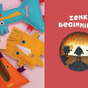 Four colorful hand-sewn softies rest on a pink backdrop. Nearby, a red panel shows The Zenki Way by Schiffer Publishing, Ltd., with white text above shadowy figures around a fire, capturing the playful spirit of the Zenki Method.