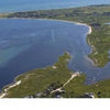 Aerial view of a coastal bay with beaches, marshland, and homes along the shore with anchored boats—ideal for Nantucket Vistas by Schiffer Publishing, Ltd. or as a highlight in any Nantucket-themed souvenir collection.