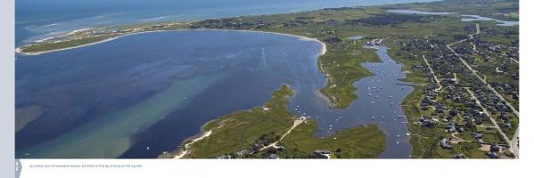 Aerial view of a coastal bay with beaches, marshland, and homes along the shore with anchored boats—ideal for Nantucket Vistas by Schiffer Publishing, Ltd. or as a highlight in any Nantucket-themed souvenir collection.